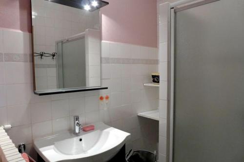 ein Badezimmer mit Waschbecken und Spiegel in der Unterkunft Les pivoines in Richebourg