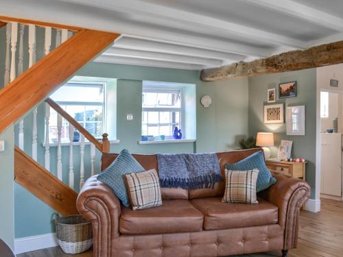 a living room with a couch and a staircase at Peace Cottage in Flamborough