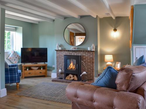 a living room with a couch and a fireplace at Peace Cottage in Flamborough