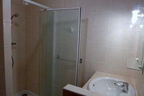eine Dusche mit Glastür neben einem Waschbecken in der Unterkunft Le paradis des goncourt in Goncourt
