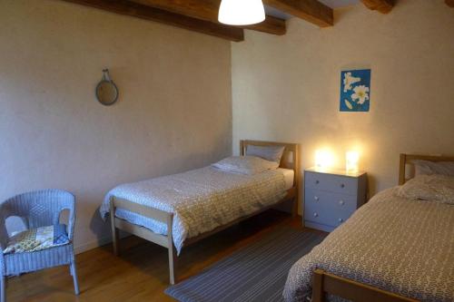 een kleine slaapkamer met 2 bedden en een stoel bij Les jardins de recourt in Récourt