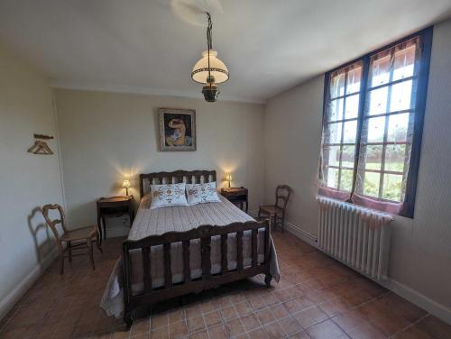 een slaapkamer met een bed en twee ramen bij Villa antigone in Vaux-sous-Aubigny