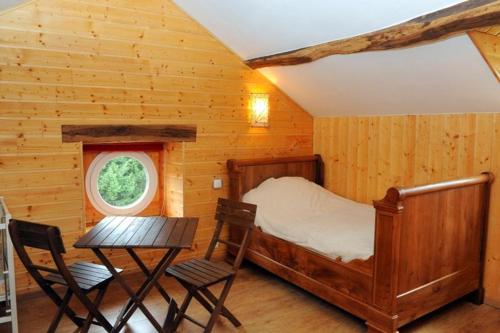 une chambre avec un lit, une table et des chaises dans l'établissement Le routoir, à Fayl-Billot