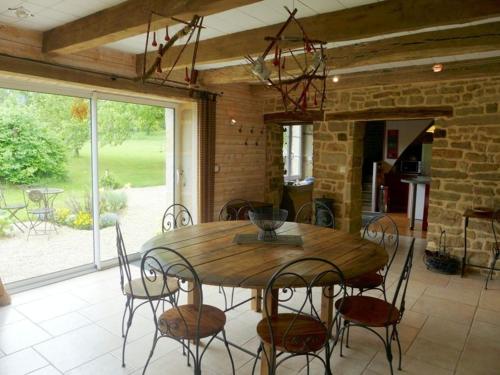 une salle à manger avec une table et des chaises en bois dans l'établissement Le routoir, à Fayl-Billot