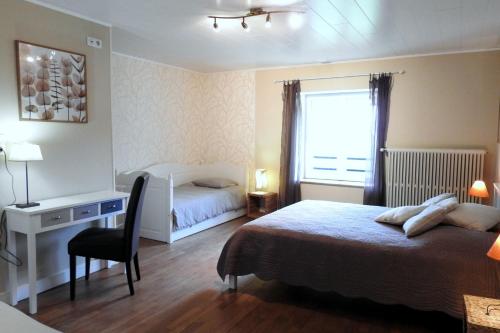 ein Schlafzimmer mit Bett, Schreibtisch und Fenster in der Unterkunft Gite de la fontaine in Saint-Blin