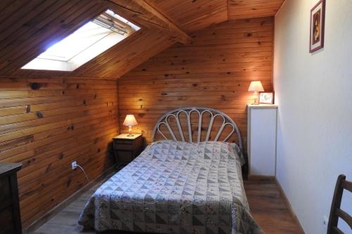 een slaapkamer met een bed in een kamer met houten wanden bij La verte vallee in Orbigny-au-Val