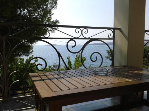 a bench on a balcony with a view of the ocean at Niriides in Galaxidhion