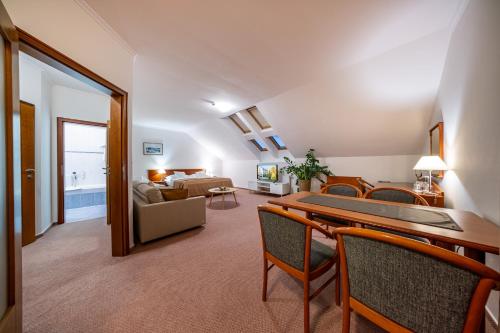 a living room with a table and chairs and a couch at April hotel Panorama in Rychnov nad Kněžnou