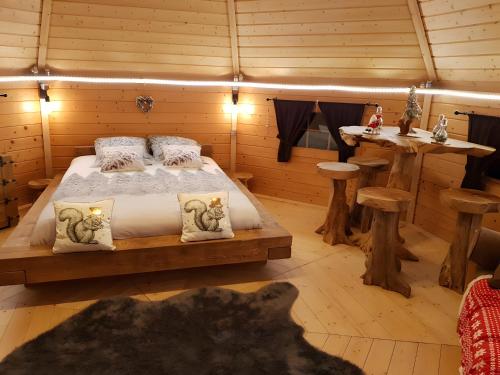a bedroom with a bed in a log cabin at Chambre Insolite L'écureuil in Coligny