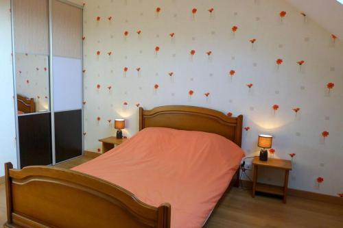 - une chambre avec un lit orné de fleurs rouges sur le mur dans l'établissement Les jonquilles, à Vignes-la-Côte