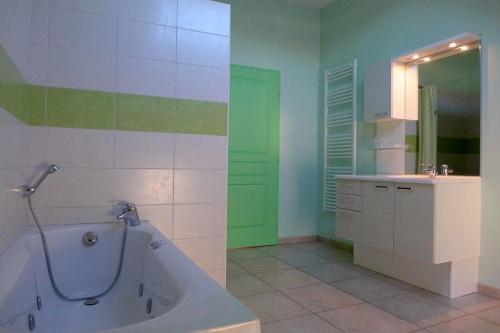 une salle de bains avec baignoire et lavabo dans l'établissement Les jonquilles, à Vignes-la-Côte