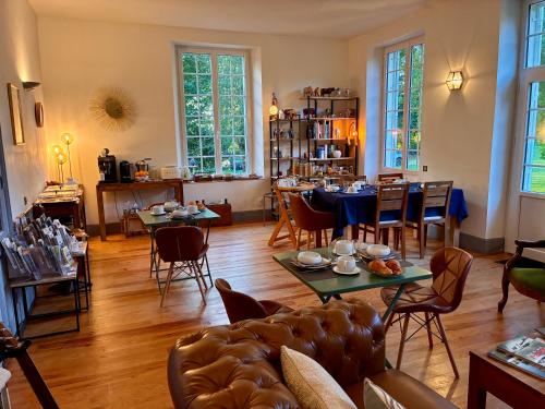 トレシー・シュル・メールにあるLa Villa Mirabelle 2min d'Arromanches-les-Bainsのソファとテーブルと椅子のあるリビングルーム