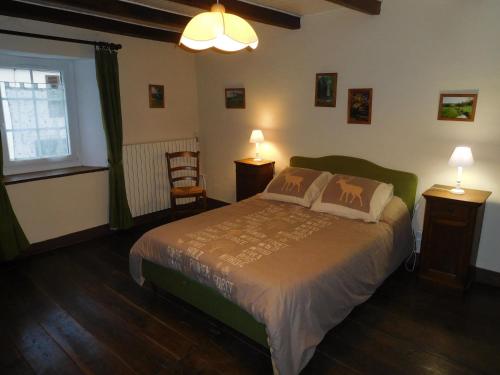 ein Schlafzimmer mit einem Bett, zwei Tischen und einem Fenster in der Unterkunft La maison de gabrielle in Giey-sur-Aujon