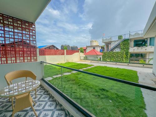 ein Balkon mit Tisch und Stühlen und ein Garten in der Unterkunft Grand Continent Morjim in Morjim