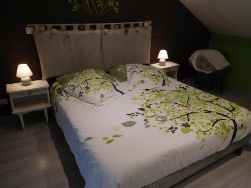 een bed met een wit dekbed en twee nachtkastjes bij La p'tite cuisine in Faverolles