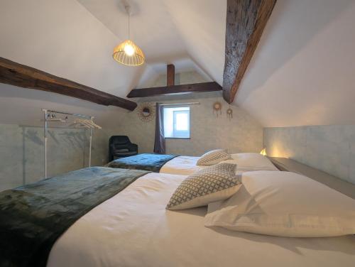 een slaapkamer met een groot bed met twee kussens bij Gite simone de beauvoir in Châteauvillain