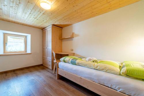 sypialnia z łóżkiem w kącie pokoju w obiekcie Ospitalità Diffusa Laste Dolomites Cèsa del Bèrba Jaco w mieście Colle Santa Lucia