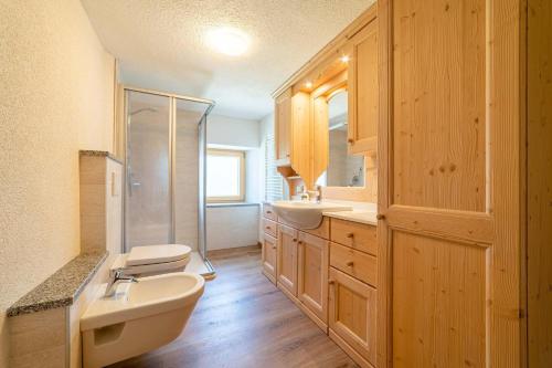 łazienka z dwiema umywalkami, toaletą i prysznicem w obiekcie Ospitalità Diffusa Laste Dolomites Cèsa del Bèrba Jaco w mieście Colle Santa Lucia