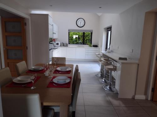 a kitchen with a table and a clock on the wall at Park Avenue in Newcastle