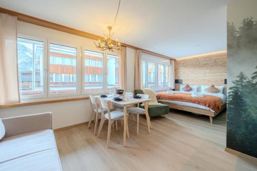 ein Wohnzimmer mit Tisch und ein Schlafzimmer in der Unterkunft Collina Comfort Design-Studio by Arosa Vacations in Arosa