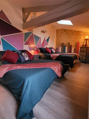 a room with three beds in a room with a wall at Villa la Hulotte in Angles