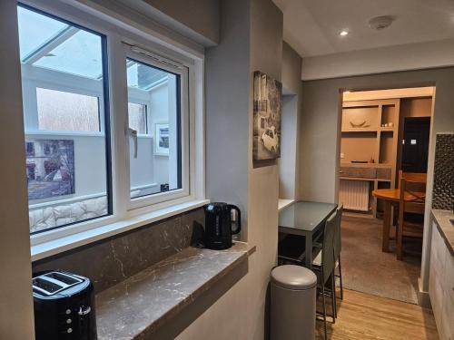 een kleine kamer met een raam en een bureau bij Tastefully decorated modern home in Nantwich