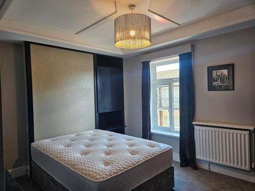 een slaapkamer met een bed en een raam bij Tastefully decorated modern home in Nantwich