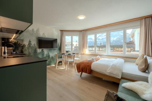 a bedroom with a bed and a kitchen with a table at Collina Forest Design-Studio by Arosa Vacations in Arosa