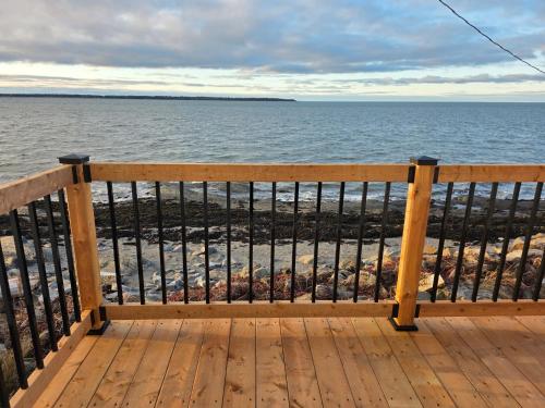 a wooden deck with a view of the ocean at Motel Rimouski in Rimouski