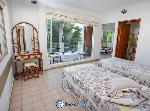 una camera da letto con due letti e un balcone con un tavolo di Quinta Celeste a Temixco