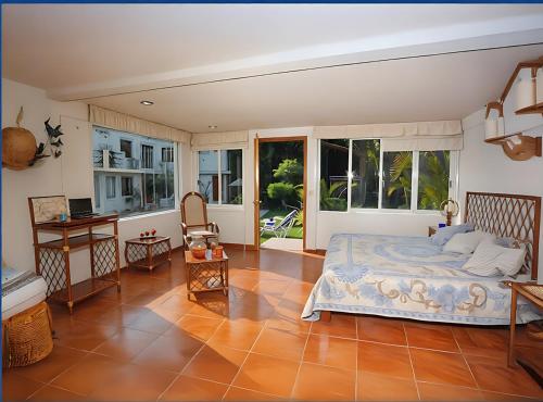 ein Schlafzimmer mit einem Bett, einem Schreibtisch und Fenstern in der Unterkunft Quinta Celeste in Temixco