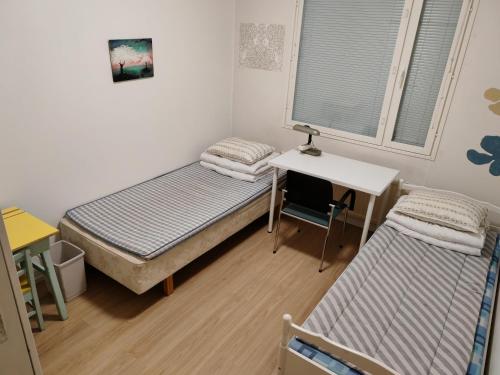 een kleine kamer met een bed en een bureau bij Laajavuoren majapaikka — Condo in Laajavuori in Jyväskylä