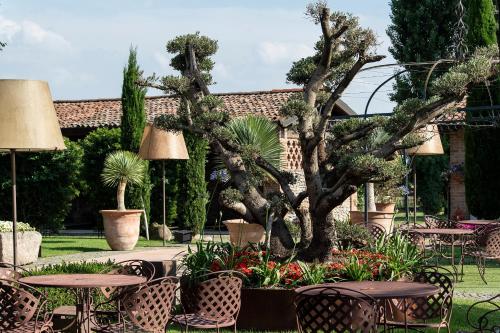 a garden with tables and chairs and a tree at La Colombera Ristorante - Albergo in Castrezatto