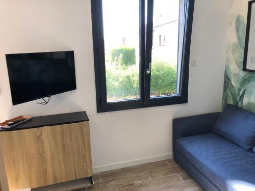 un salon avec un canapé et une télévision à écran plat dans l'établissement Appart'Hotel au Pradet, au Pradet