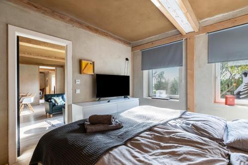 ein Schlafzimmer mit einem großen Bett und einem Flachbildfernseher in der Unterkunft Lehmhuus in Klanxbüll