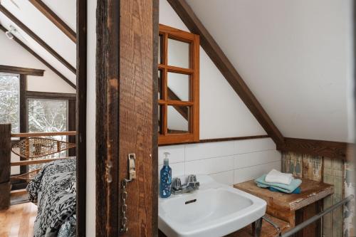 a bathroom with a sink and a bed in a room at Chalet Vintage with Private SPA & Sauna on the Lakeside in Labelle