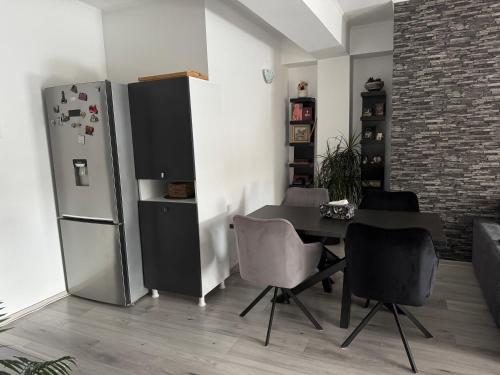 a dining room with a table and a refrigerator at Jules Cozy Place in Bucharest