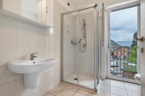 a bathroom with a sink and a shower with a window at La casa di Romi in Mori