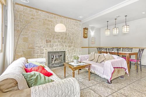 - un salon avec deux canapés et un mur en pierre dans l'établissement Ca Lluis, à Campell