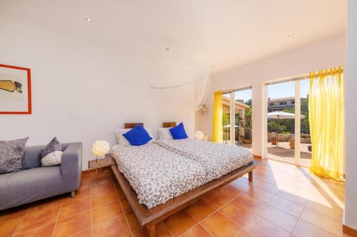 una camera da letto con un letto e un divano di Villa Sol a Cala Figuera