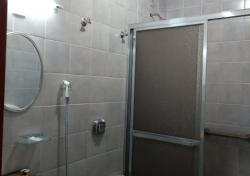 Un baño con ducha con puerta de cristal en Hotel e Pousada Ciconha-são Lourenço MG, en São Lourenço