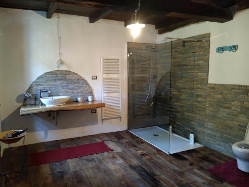 Ca' Rionda - Antica Casa Rurale في Osiglia: حمام مع دش زجاجي ومغسلة