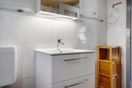 une salle de bain blanche avec un lavabo et des toilettes dans l'établissement Ferienhaus Am Darß - Kogge, à Pruchten