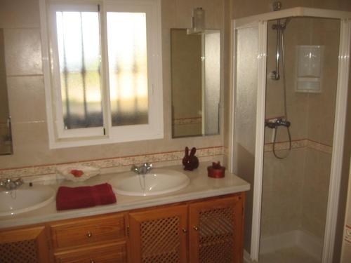 un bagno con due lavandini e una doccia di Villa Roca a Estepona