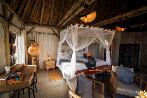 a bedroom with a bed with a canopy at Tsauchab River Camp in Sesriem
