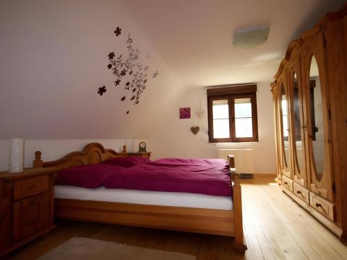 a bedroom with a bed with purple sheets and a window at Ferienhaus Paula in Langenbrand
