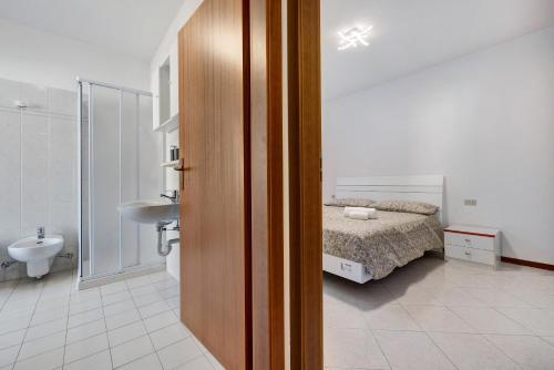 una camera da letto con un letto e un bagno con un lavandino di Appartamento Cuore di Comano a Comano Terme