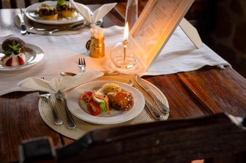 a table with plates of food on a wooden table at Tsauchab River Camp in Sesriem