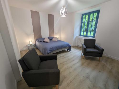 een slaapkamer met een bed, een bank en een stoel bij Le nancery in Langres