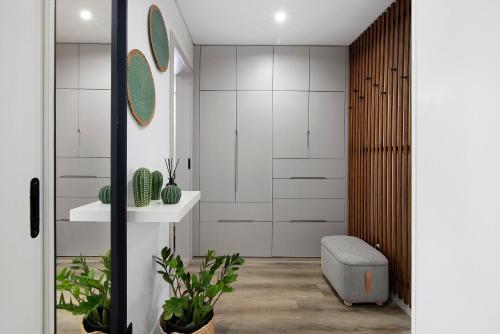 ein Badezimmer mit weißen Schränken und einem Waschbecken in der Unterkunft Casa das Amendoeiras in Pechão